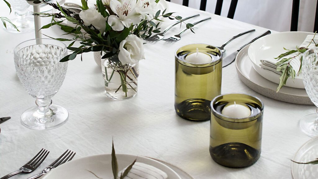 Floating candles in cut wine bottles on a tablescape